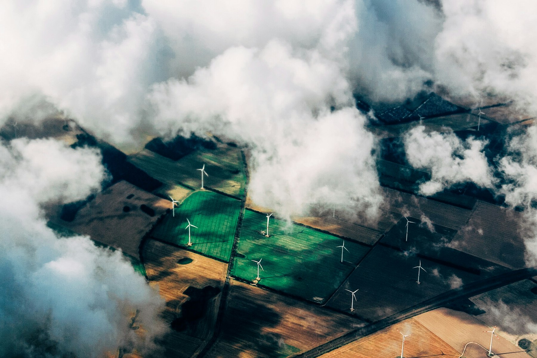 Aerial view of wind turbines standing in farmland