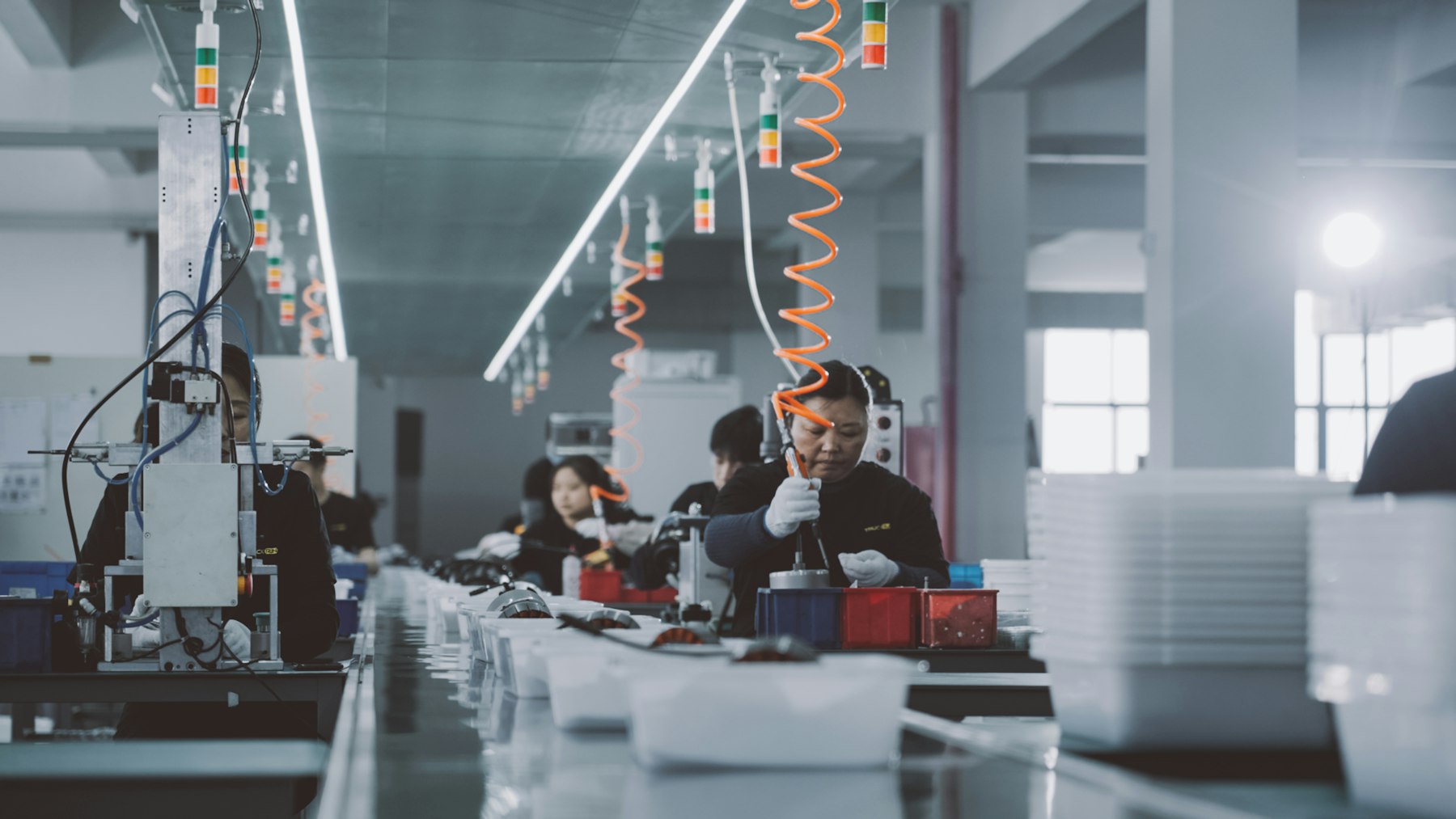 Electronics assembly line with people working at their stations