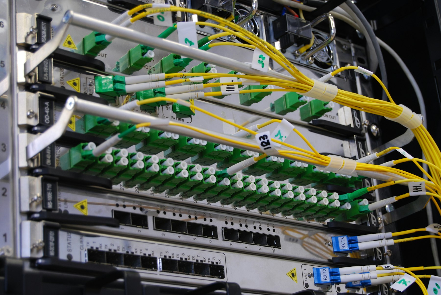 Fibre optic cables patched into a network switch in a rack